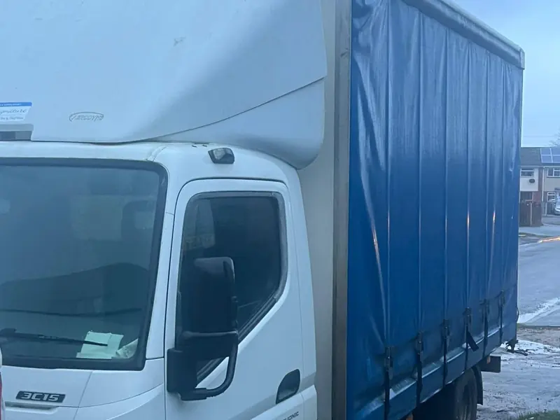 Our white removal truck with its blue curtain side, parked at the roadside