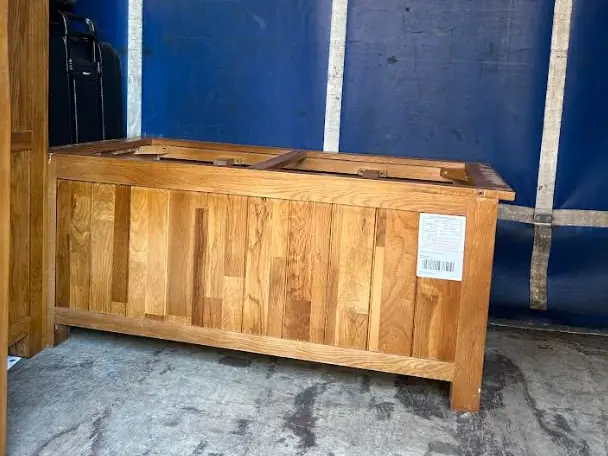 Oak sideboard strapped inside our removal truck against the blue curtain