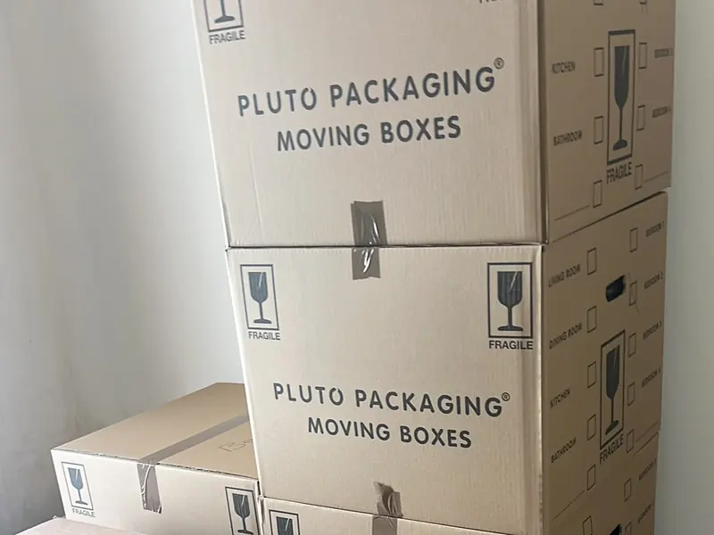 Stack of sealed cardboard moving boxes marked fragile, packed and ready to be loaded